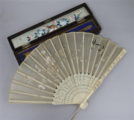 A 19th century Chinese ivory and embroidered silk fan in a lacquer box.